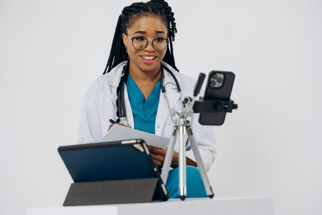 Smiling female doctor providing online consultation using a smartphone. Healthcare and technology meet in a virtual setting.